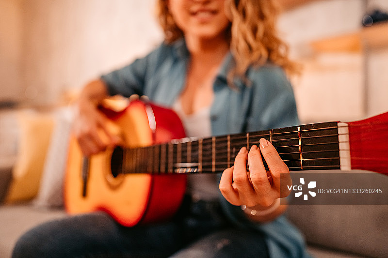 在家弹奏原声吉他的妇女图片素材