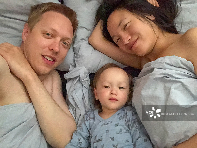 在床上的一家幸福家庭肖像图片素材