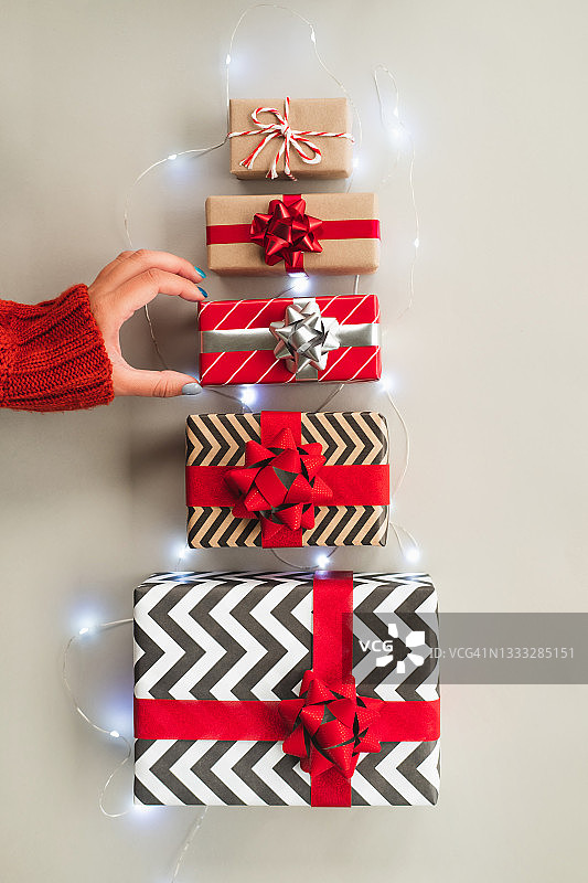 终极灰色背景上由五个不同礼品盒制成的冷杉树，配有花环图片素材