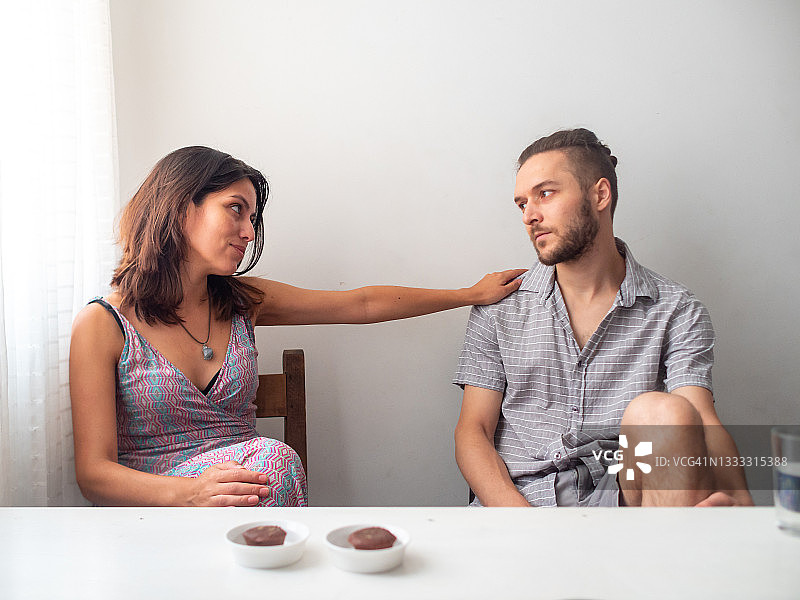 在窗边看着白房间里白人男人的拉丁裔女人图片素材