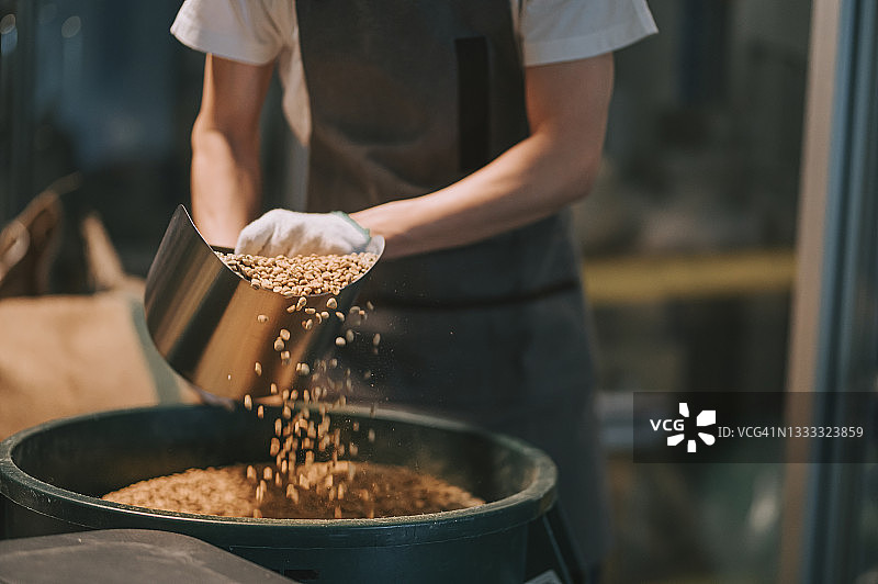 亚洲工人在仓库中烘焙咖啡豆特写图片素材