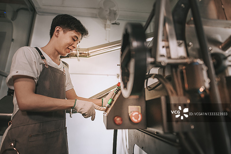 操作咖啡烘焙机的中国工人图片素材