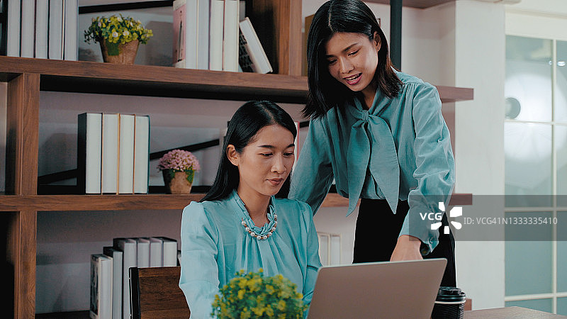 两位年轻的亚洲女商人在办公室合作图片素材