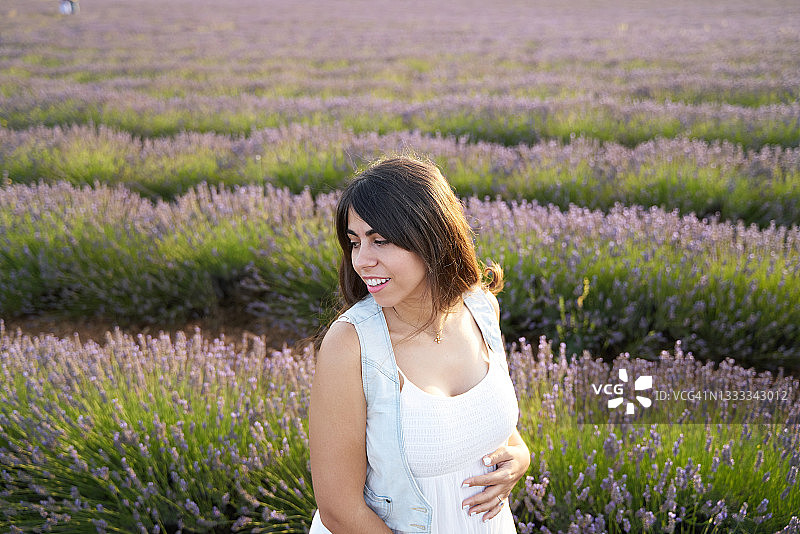 快乐孕妇站在薰衣草田里图片素材