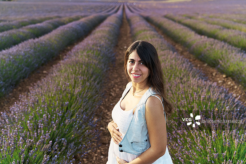 年轻女人在薰衣草田中微笑图片素材