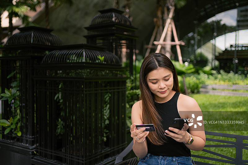 亚洲女性用手机和信用卡购物图片素材