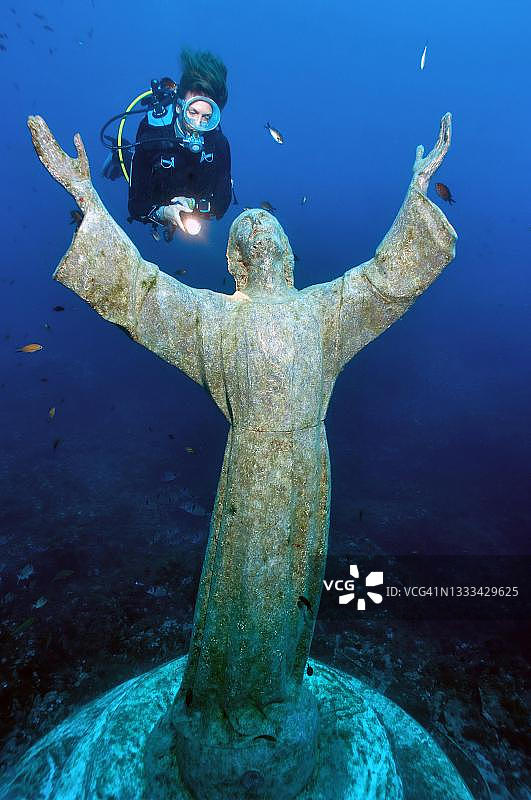 潜水员在地中海圣弗鲁托索的基督雕像旁，意大利利古里亚波托菲诺半岛图片素材