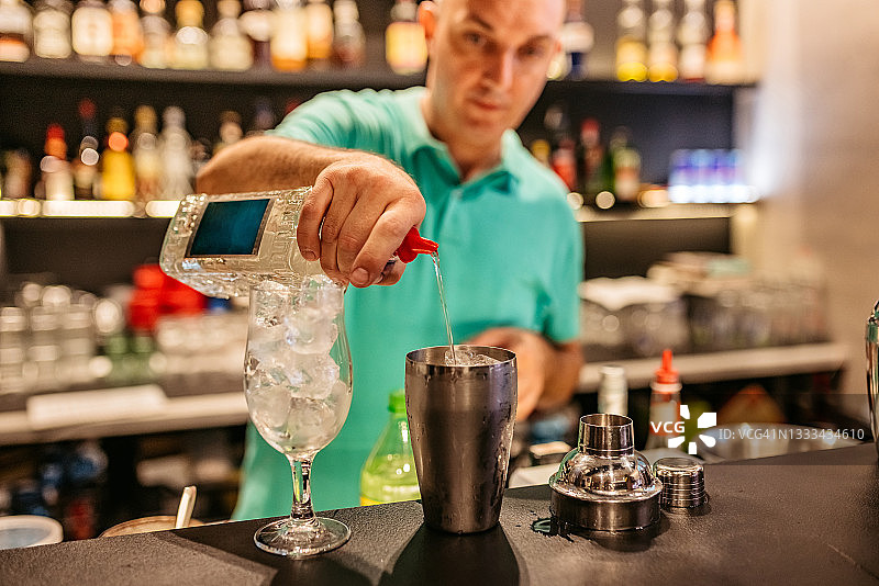调酒师在吧台调制鸡尾酒图片素材