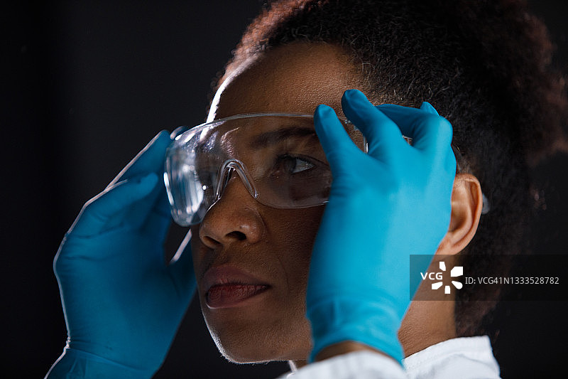戴防护眼镜的严肃女科学家图片素材