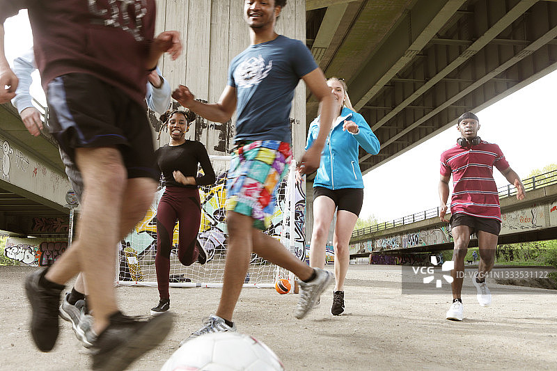 一群年轻人在城市里踢足球图片素材