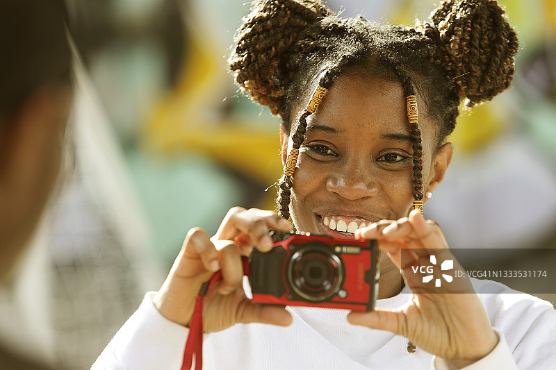 年轻女人用相机给朋友拍照图片素材