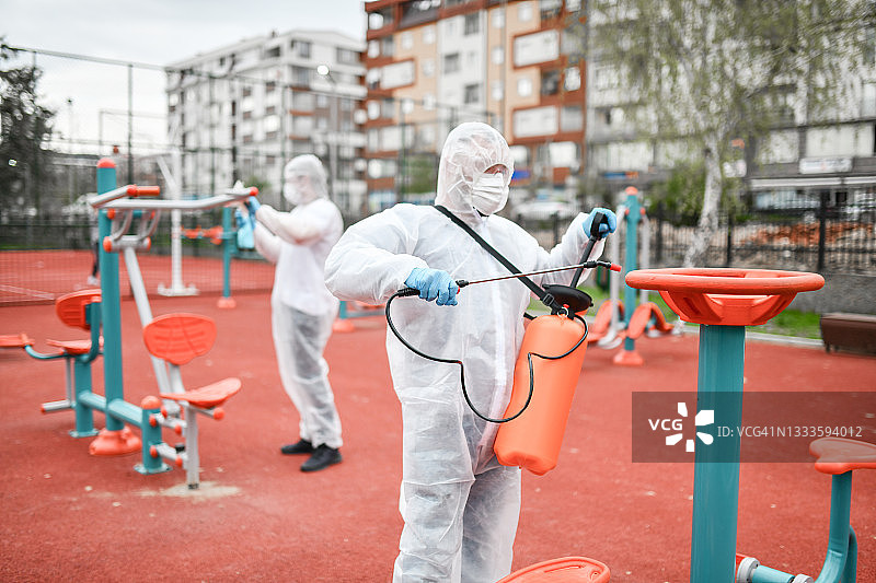 医护人员对户外健身器材进行消毒，预防新冠图片素材