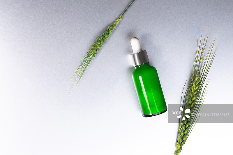 含麦胚油的绿色化妆品液体玻璃瓶（扁平风格）图片素材