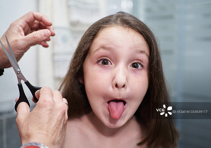 儿童剪发，面部表情搞怪吐舌图片素材