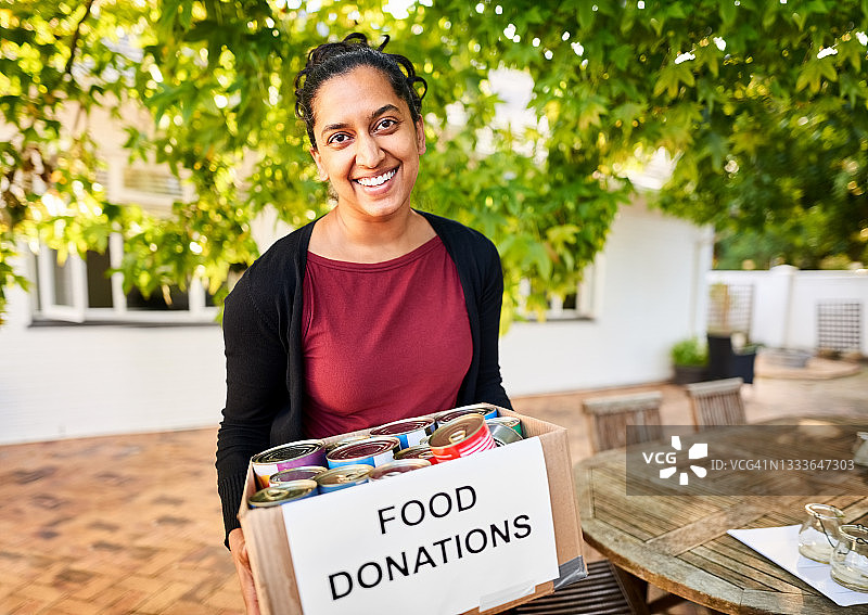 在社区中心拿着食物捐赠箱的女人图片素材