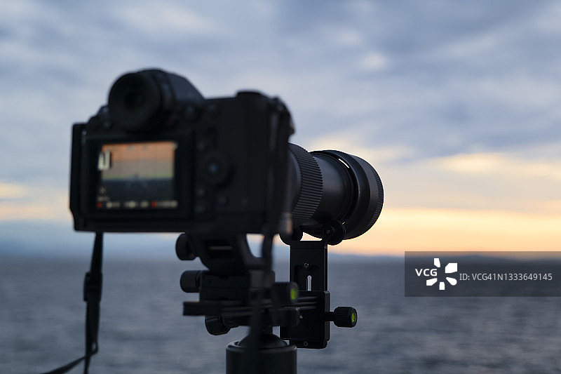 日出时分，使用微单数码相机和长焦镜头在海边拍摄风景照片图片素材