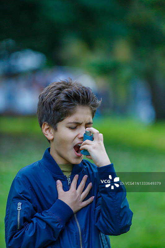 在公园使用哮喘吸入器的男孩图片素材