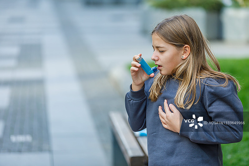 可爱女孩使用吸入器治疗呼吸问题图片素材