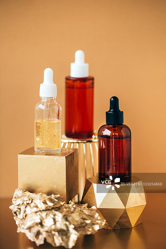 摆放在金色台座上的面部精华玻璃瓶图片素材