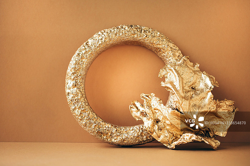 米色背景上的圆形和抽象形金色装饰品，具有复制空间的潮流模型，前视图图片素材