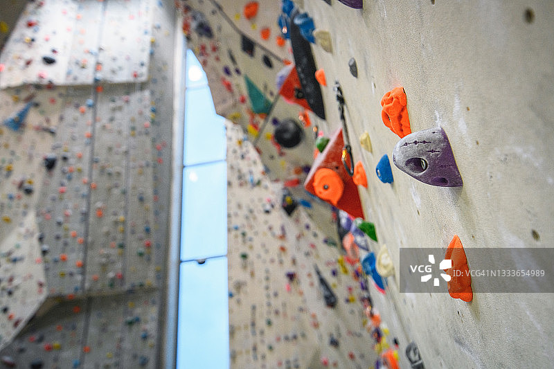 攀岩馆内固定在垂直墙壁上的彩色岩点图片素材