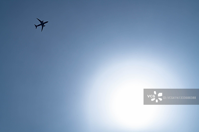 阳光下飞越日本神奈川县上空的飞机图片素材