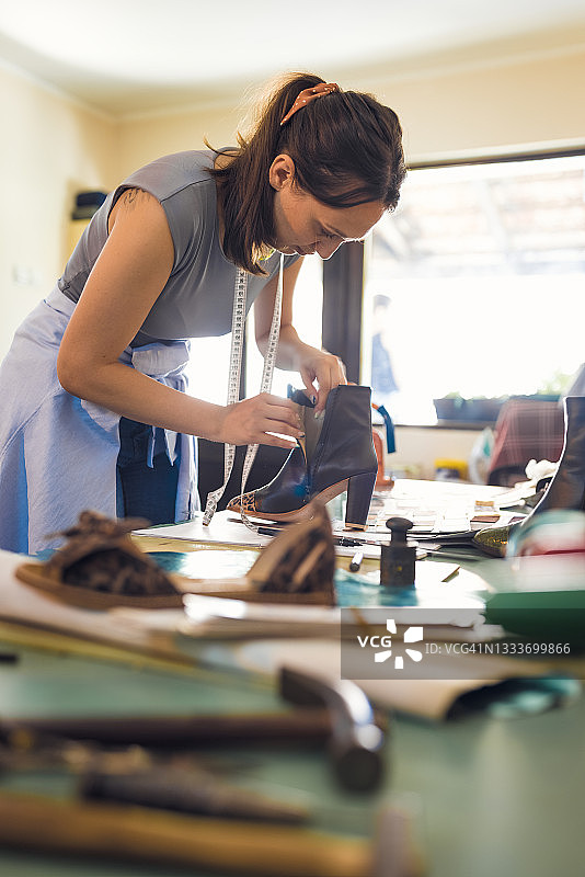在她的工作室工作的制鞋匠女孩图片素材