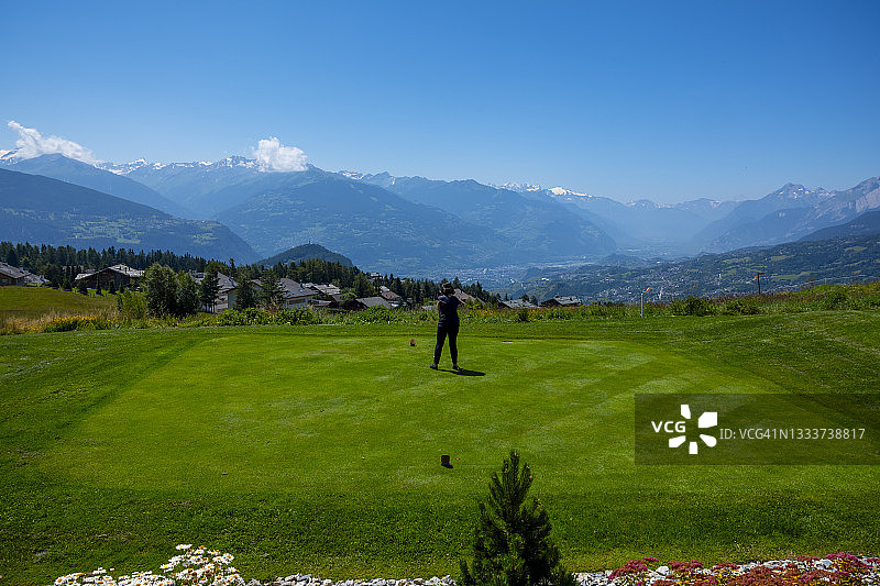 女子在克莱恩·蒙塔纳高尔夫球场开球，可欣赏山景图片素材