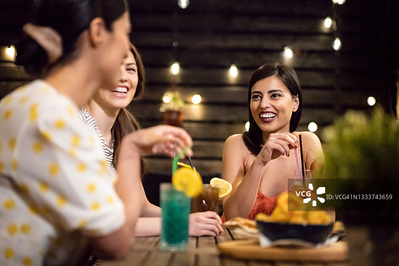 在小酒馆户外开怀畅饮的闺蜜们图片素材