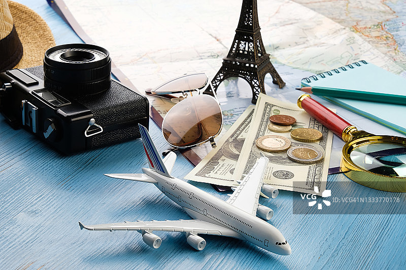 夏季假日物品：相机、太阳镜、现金、草帽、地图和旅行计划。木质背景上的旅行者旅游布局和配件，开放边界概念，享受快乐旅行，文本空间副本图片素材