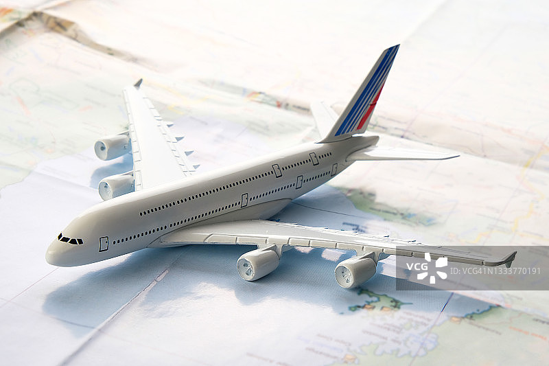 夏季假日用品：商用飞机模型、地图和旅行计划。旅游布局 - 旅行者的一套用品和配件，在木制背景上。快乐旅程的开放边界概念。文本空间副本。图片素材