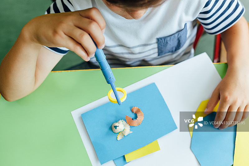 在美术课上用纸和铅笔的男孩图片素材