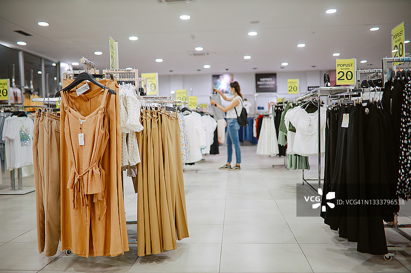 购物中心内的服装区，背景是购物的女人图片素材