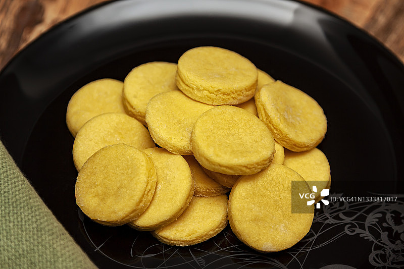 黑盘子里的自制黄色黄油饼干图片素材