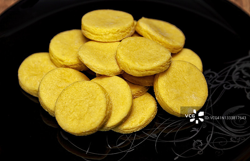 黑盘子里的自制黄色黄油饼干图片素材
