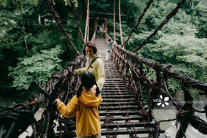 母亲和孩子穿过日本四国祖谷的藤桥图片素材