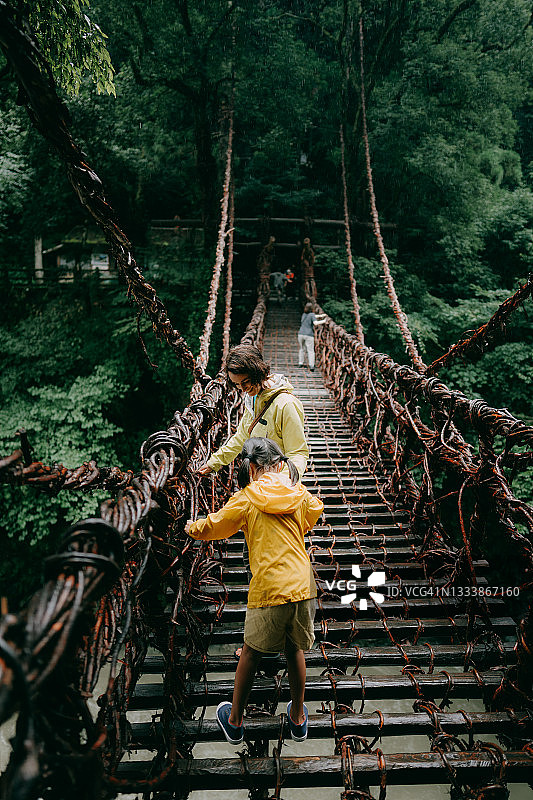 母亲和孩子穿过日本四国祖谷的藤桥图片素材