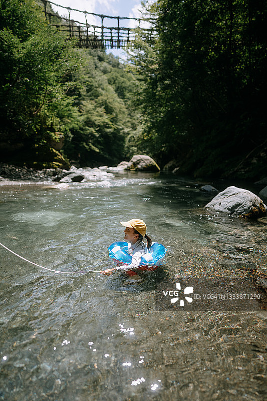 年轻女孩在日本祖谷溪清澈的河水中玩耍图片素材
