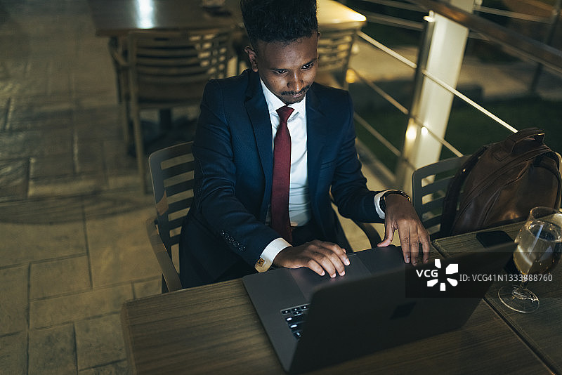 在咖啡店休息时使用笔记本电脑的商人图片素材