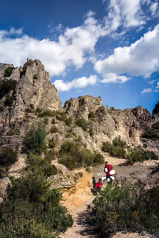 父亲、女儿和狗在地中海炎热的夏天里爬山图片素材
