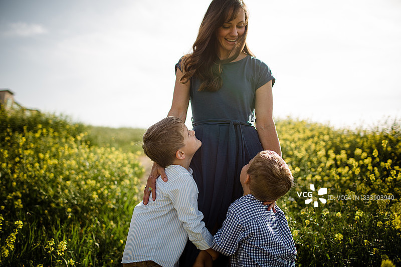 母亲和儿子们站在野花田中图片素材