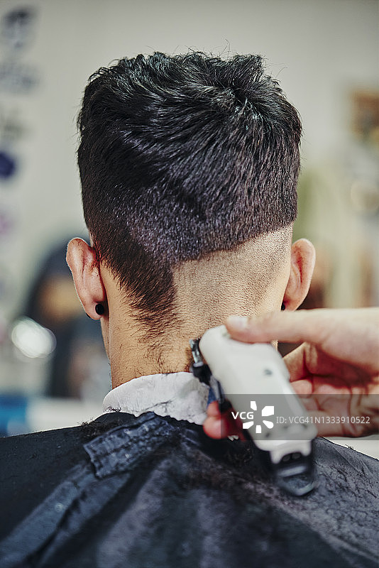 发型师用电动理发器为小男孩理发图片素材