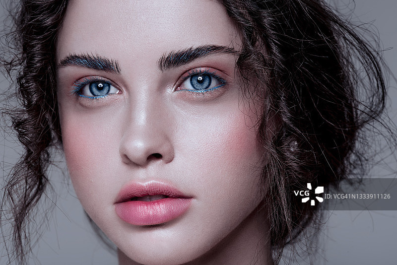 美丽的蓝发美人鱼，化着蓝色闪光妆，头戴珠宝，湿发造型，娃娃脸图片素材