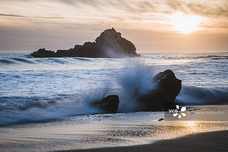 日落时分，海浪拍打着巨浪比克斯海滩的岩石，加利福尼亚州图片素材