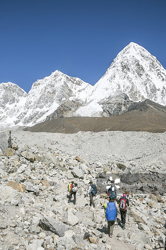 攀岩队穿越冰碛，背景是普莫里峰图片素材