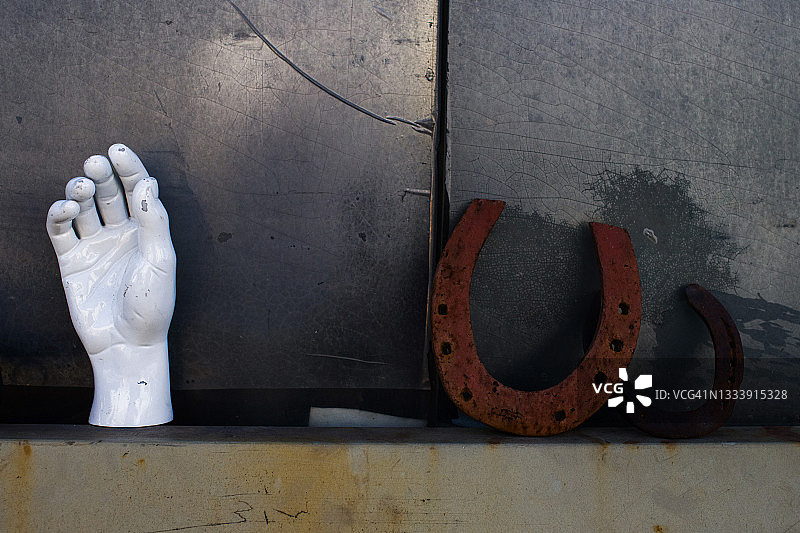 假人手与生锈马蹄铁图片素材