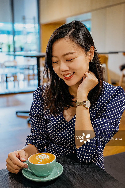 年轻亚洲女性在咖啡馆里喝咖啡休息图片素材