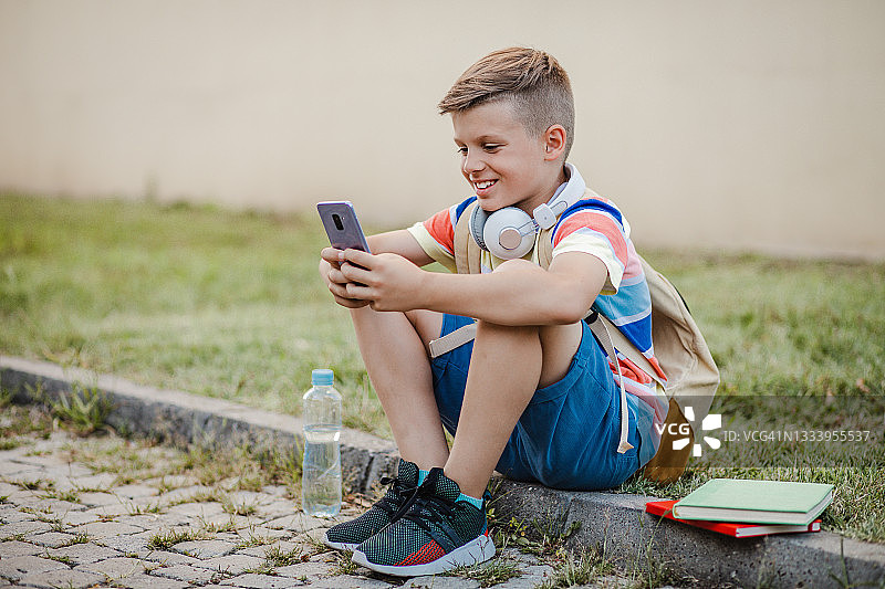 放学后使用手机的小男孩图片素材