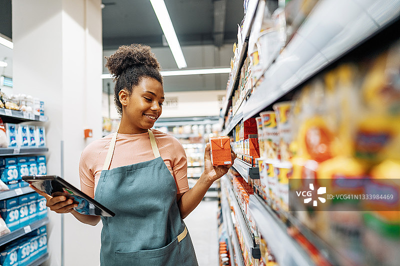 超市员工使用数字平板电脑组织供应链的交付图片素材