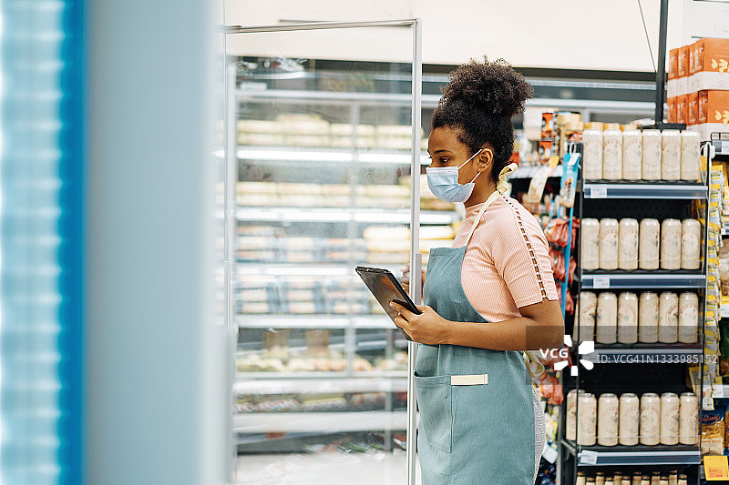 超市员工使用数字平板电脑组织供应链的交付图片素材